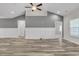 Spacious and versatile living room with stylish wood-look floors, neutral paint, and a modern ceiling fan at 383 Hayloft Circle, Conway, SC 29526