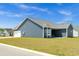 View of the back of the house, featuring blue siding, an attached two-car garage and back patio at 383 Hayloft Circle, Conway, SC 29526