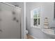 Clean bathroom with a walk-in shower, a pedestal sink, and bright natural light from the window at 4003 N Ocean Blvd., Myrtle Beach, SC 29577