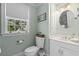 Charming bathroom with a toilet, white vanity, and window with a view of the trees at 4003 N Ocean Blvd., Myrtle Beach, SC 29577