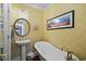 Elegant bathroom featuring a freestanding tub, pedestal sink, and gold fixtures at 4003 N Ocean Blvd., Myrtle Beach, SC 29577
