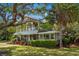 Charming two-story home with a covered porch and balcony, surrounded by mature trees and lush landscaping at 4003 N Ocean Blvd., Myrtle Beach, SC 29577