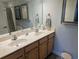 Dual sink bathroom with decorative mirrors, towel racks, and cabinet space at 407 24Th Ave. N # 302, North Myrtle Beach, SC 29582