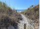 Beautiful sandy beach path surrounded by beach grasses that leads to ocean at 407 24Th Ave. N # 302, North Myrtle Beach, SC 29582
