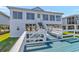 Exterior of a stilted beach house featuring a spacious deck with built-in benches and stairs at 414 32Nd Ave. N, North Myrtle Beach, SC 29582