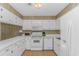Well-lit kitchen featuring white appliances, cabinets, and countertops, providing a clean and functional cooking space at 414 32Nd Ave. N, North Myrtle Beach, SC 29582