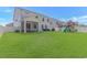 Wide shot of an expansive backyard with a screened porch, patio seating, and a play area at 456 Cattle Drive Circle, Myrtle Beach, SC 29588