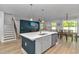 Open-concept kitchen island with a sink, stainless steel dishwasher, leading to the staircase and living area at 456 Cattle Drive Circle, Myrtle Beach, SC 29588