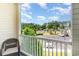 Balcony view of parking lot, lush trees, and clear blue sky with clouds for a picturesque outdoor setting at 488 River Oaks Dr. # 61F, Myrtle Beach, SC 29579