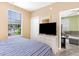 Bedroom with a dresser and TV, window overlooking the parking area, and view to a living room at 488 River Oaks Dr. # 61F, Myrtle Beach, SC 29579