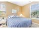 Comfortable bedroom featuring a bed with blue-striped bedding, bright natural light, and two side tables at 488 River Oaks Dr. # 61F, Myrtle Beach, SC 29579