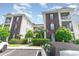 Well-maintained condo building with brick facade, green shutters, and landscaped grounds at 488 River Oaks Dr. # 61F, Myrtle Beach, SC 29579