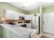 Well-lit kitchen featuring white cabinetry, modern appliances, and laminate flooring at 488 River Oaks Dr. # 61F, Myrtle Beach, SC 29579