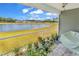 Relaxing back porch overlooking a serene lake with vibrant flowers, providing a peaceful outdoor retreat at 528 Courtridge Loop, Conway, SC 29526