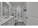 Well-lit bathroom with white cabinets, dual sinks, a shower with glass doors, and a tiled floor at 528 Courtridge Loop, Conway, SC 29526