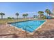 Outdoor pool with brick trim, railings, palm trees and lush green grass, providing a tranquil oasis at 5300 N Ocean Blvd. # 422, Myrtle Beach, SC 29572