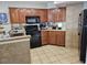 Cozy kitchen featuring wooden cabinets, black appliances, and tile flooring for a functional cooking space at 5300 N Ocean Blvd. # 518, Myrtle Beach, SC 29577