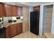 Practical kitchen area with wood cabinets, neutral countertops, a black refrigerator, and convenient pantry storage at 5300 N Ocean Blvd. # 518, Myrtle Beach, SC 29577