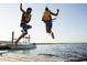 leaping off a pier into the water with a boat and the shoreline in the background at 532 Magnolia Terrace Dr, Myrtle Beach, SC 29579