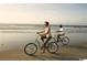 Two people riding bicycles on the beach, showcasing recreational opportunities at 534 Magnolia Terrace Dr, Myrtle Beach, SC 29579