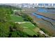 Scenic aerial view of a lush green golf course near the water, with trees and cityscape in the background at 534 Magnolia Terrace Dr, Myrtle Beach, SC 29579