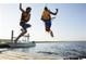 Two people jumping off a dock into the water, promoting water activities at 534 Magnolia Terrace Dr, Myrtle Beach, SC 29579