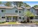 Inviting townhome exterior with a tidy lawn, mature trees, and reserved parking spaces in a desirable neighborhood at 55 Shadow Moss Pl. # 55, North Myrtle Beach, SC 29582