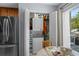 Functional laundry closet featuring a stacked washer and dryer unit and storage shelves in a light blue dining area at 55 Shadow Moss Pl. # 55, North Myrtle Beach, SC 29582