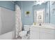 This bathroom has blue accent paint, a vanity, a toilet, and a shower/tub combo at 5751 Oyster Catcher Dr. # 334, North Myrtle Beach, SC 29582