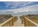 Charming wooden walkway providing easy access to the beach, offering a picturesque view of the ocean and sky at 5751 Oyster Catcher Dr. # 334, North Myrtle Beach, SC 29582