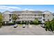 Charming condo complex with multiple stories, white balconies, well-maintained landscaping and convenient parking spaces at 5751 Oyster Catcher Dr. # 334, North Myrtle Beach, SC 29582
