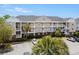 Exterior view of a multi-story condo building with balconies and lush landscaping at 5751 Oyster Catcher Dr. # 334, North Myrtle Beach, SC 29582