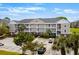Exterior view of a multi-story condo building with parking, landscaping, and balconies at 5751 Oyster Catcher Dr. # 334, North Myrtle Beach, SC 29582