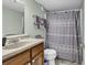 Bathroom featuring a vanity, sink, toilet, and shower with neutral colored patterned curtain, complemented by soft lighting at 5905 South Kings Hwy. # 135, Myrtle Beach, SC 29575