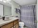 Bathroom features a vanity, sink, toilet, and shower with a patterned curtain in neutral tones, complemented by soft lighting at 5905 South Kings Hwy. # 135, Myrtle Beach, SC 29575