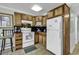 Well-lit kitchen featuring wood cabinetry, white appliances, and dark countertops at 5905 South Kings Hwy. # 135, Myrtle Beach, SC 29575
