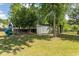 Large backyard featuring mature trees, a storage shed, and a playset at 601 Blue Daisy Ct., Loris, SC 29569