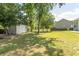 Spacious backyard featuring a storage shed, mature trees and partial fence at 601 Blue Daisy Ct., Loris, SC 29569