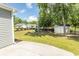 Spacious backyard with grass, mature trees, playground, and storage shed at 601 Blue Daisy Ct., Loris, SC 29569
