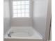Relaxing soaking tub with chrome hardware under a bright window in this bathroom at 601 Blue Daisy Ct., Loris, SC 29569