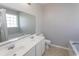 Bathroom featuring double sinks, a large mirror, toilet and relaxing soaking tub with tiled floors at 601 Blue Daisy Ct., Loris, SC 29569