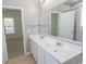 Bathroom featuring double sinks, a large mirror, tiled floors and a door to the shower at 601 Blue Daisy Ct., Loris, SC 29569