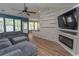 The living room features a decorative wall feature, wood-look flooring, and a comfortable gray sectional at 601 Blue Daisy Ct., Loris, SC 29569