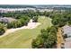 Aerial view of Greg Norman golf course featuring manicured greens, sand traps, trees and nearby community at 6095 Catalina Dr. # 1613, North Myrtle Beach, SC 29582