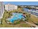 A sprawling pool area with palm trees, lounge chairs, and a bar, situated next to a waterway and white buildings at 6253 Catalina Dr. # 422, North Myrtle Beach, SC 29582