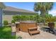 Outdoor hot tub with a wooden surround, steps, and mature landscaping providing privacy, with palm trees in the background at 631 Edgecreek Dr., Myrtle Beach, SC 29579