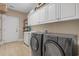 Well-equipped laundry room with washer, dryer, ample storage cabinets, and a utility sink at 631 Edgecreek Dr., Myrtle Beach, SC 29579