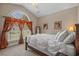 Bright main bedroom features a large window with beautiful curtains and a comfortable bed with soft bedding at 631 Edgecreek Dr., Myrtle Beach, SC 29579