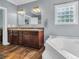 Bathroom with double sink vanity, soaking tub, and lots of natural light from a glass block window at 6357 Highway 707, Myrtle Beach, SC 29588