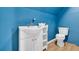 Small blue bathroom with a vintage vanity, toilet and wood-style laminate flooring at 6357 Highway 707, Myrtle Beach, SC 29588